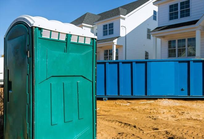 a row of portable toilets located at a busy construction site